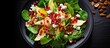 © HN Works - Healthy vegetarian food consisting of a salad composed of spinach leaves pear slices mixed nuts pomegranate seeds and feta cheese The dish is beautifully presented on a black plate and captured from