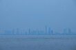 Pattaya skyline located near rippling water in a misty atmosphere, Thailand