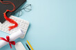 Online education completion theme. Overhead shot of keyboard, mouse, mortarboard, diploma, study materials, spectacles on soft blue backdrop with space for text or promotion