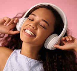 Poster - Girl, relax and listening to music with headphones for jazz or beats on a pink studio background. Happy female person enjoying podcast, audio streaming or sound with smile for radio, song or playlist