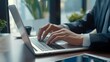 © best stock - Business man working on laptop computer at modern office. Businessman in black suit working and typing on laptop keyboard, surfing the internet with digital tablet on office table