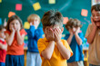 © TENphoto - A little boy covering his face with his hands is bullied by his classmates.