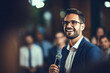 © Tetiana - Generative AI illustration motivational speaker with microphone in hand in front of audience at conference room