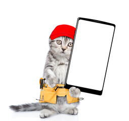 Poster - Funny cat worker wearing red cap and toolbelt standing on hind legs and  shows big smartphone with white blank screen in it paw.  Isolated on white background