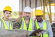 © JU.STOCKER - Engineer and foreman worker team checking project at precast concrete factory site, Engineer and builders in hardhats discussing on construction site