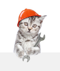 Poster - Cute kitten wearing hardhat holding the wrench and looking above blank white banner. Isolated on white background