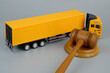 Judge gavel and truck on grey background. Legal question of export, import, taxes and transportation.