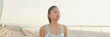 © Andrii Nekrasov - Asian girl in sports top walking outside at morning time, Panorama