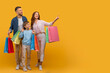 © Prostock-studio - A man and a woman stand holding shopping bags while next to a child, surrounded by a shopping environment. The trio appears to be engaged in a family outing or shopping trip, copy space