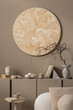 © FollowTheFlow - Creative composition of living room interior with round wall panel, brown sideboard, stylish coffee table, gray vase with branch, beige sofa, pillows and personal accessories. Home decor. Template.