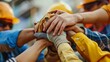 © antkevyv - Hands-on skill building, construction workers in hardhats joining their hands together to show unity teamwork