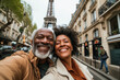 © Tixel - Smiling couple enjoys a moment capturing a selfie with the Eiffel Tower in the background in Paris