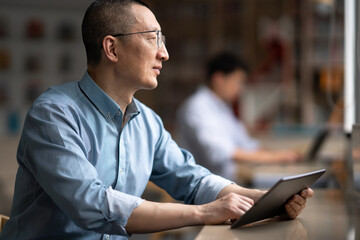 Wall Mural - businessman using tablet in library