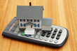 © Karen Roach - A house and calculator on a wood desk