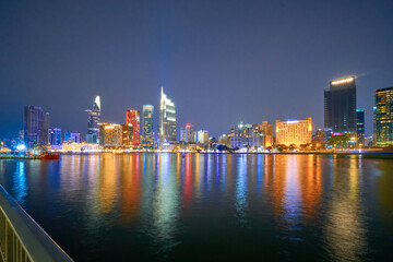 Wall Mural - Ho Chi Minh City skyline and the Saigon River. Amazing colorful night view of skyscraper and other modern buildings at downtown. Travel concept