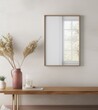 white wall with wooden frame mockup, reflections on the glass of window in the frame, pink vase and dried grass near it, modern style