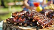 © Plaifah - A family enjoying a picnic with a platter of grilled pork ribs, relishing the camaraderie and delicious food.
