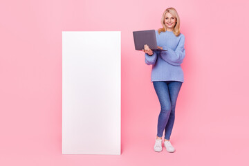 Sticker - Full length photo of senior blond lady hold laptop near promo wear pullover jeans sneakers isolated on pink background