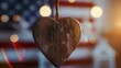 Wooden heart hanging in front of blurred American flag background