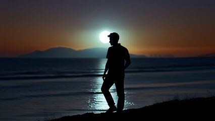 Wall Mural - Silhouette of Man Standing by the Ocean at Sunset