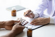 © Wasan - Specialized doctor is explaining taking medicine to a patient. Health and medicine consultation.