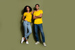 Full body portrait of two nice people posing empty space ad wear t-shirt isolated on khaki color background