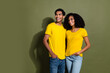 Portrait of two nice people look empty space wear t-shirt isolated on khaki color background
