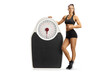 © Ljupco Smokovski - Fit female athlete pointing at a big weight scale