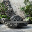 Sleek black stone display stand set against a backdrop of smooth boulders and minimalist greenery, perfect for showcasing outdoor or adventure gear