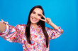 Photo of positive cute lady dressed print blouse recording video showing v-sign isolated blue color background