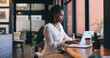 © peopleimages.com - Woman, laptop and coffee shop or remote work as virtual fashion consultant, communication or email. Black person, typing and brainstorming research for online connection, engagement or social media