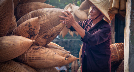 Vietnamese fishermen are doing basketry for fishing equipment at morning in Thu Sy Village, Vietnam.