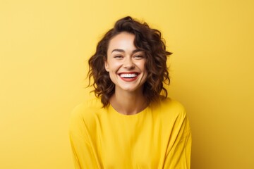 Canvas Print - Portrait of a content woman in her 30s smiling at the camera in soft yellow background