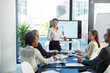 © peopleimages.com - Business woman, coach and presentation with team in meeting for discussion on corporate revenue or stock at office. Female person or speaker talking to group of employees for profit or investment