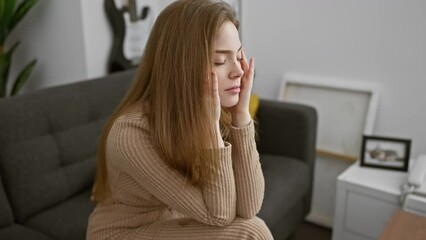 Wall Mural - Young blonde woman wearing sweater with hand on head, headache because stress. suffering migraine. at home