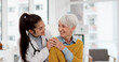 © peopleimages.com - Happy, hug and face of a doctor with a woman for medical trust, healthcare and help. Laughing, care and portrait of a young nurse with a senior patient and love during a consultation at a clinic