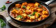 © Anastasiia - Paneer Tikka Masala in a black frying pan on a wooden board. Concept Indian Cuisine, Vegetarian Delight, Food Photography, Cooking at Home