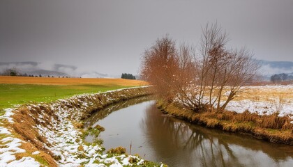 Wall Mural - winter rural landscape with brook first snow in the field winter nature nature background vertical banner