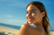 © forenna - golden sand and clear blue sky, a close-up of a young woman gracefully applying sunblock SPF cream to her shoulder. Ease of incorporating sun protection into beach activities, prom
