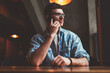 © BullRun - Young concentrated hipster guy thoughtful looking aside during important smartphone conversation, serious caucasian man calling to friend using mobile application and good wifi connection indoors