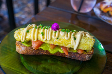 Avocado flesh is mashed with lemon juice and pepper to create guacamole. Bread is slightly toasted. Omelette can be added with tomato slices. Perfect for a quick breakfast, lunch or midday snack