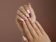 Closeup to woman hands with elegant neutral colors manicure. Beautiful natural looking gel polish manicure on square nails