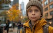 © imagineRbc - A young boy wearing a yellow jacket stands on a city street