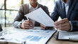 © Jaroon - Discussing tax financial contract documents with a broad group of professional colleagues at a meeting in the workplace.