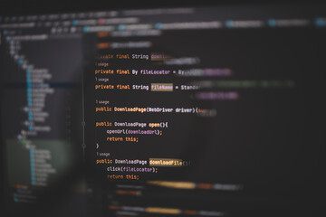 Close up of computer code under magnifying glass on computer screen