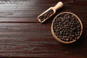 Sticker - Aromatic spice. Black pepper in bowl and scoop on wooden table, top view. Space for text