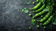 An artistic display of fresh green peas scattered on a dark textured surface