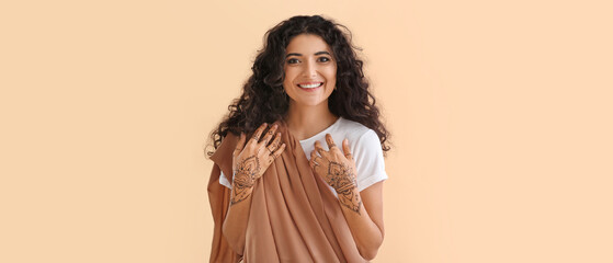 Wall Mural - Beautiful Indian woman with henna tattoo on color background