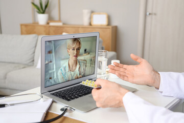 Canvas Print - Handsome doctor prescribing pills to patient online at home office, closeup