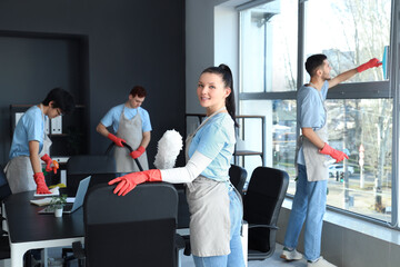 Canvas Print - Female janitor with pp-duster cleaning in office